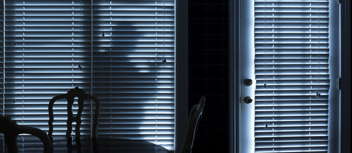 silhouette of a burglar or thief sneeking up to back door at night, criminal defense
