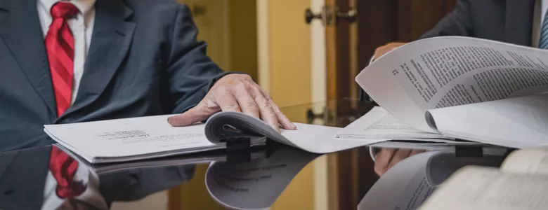 Close up of attorney's hands flipping through stacks of paper