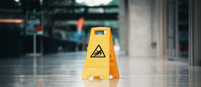 Yellow wet floor slip hazard sign in hallway