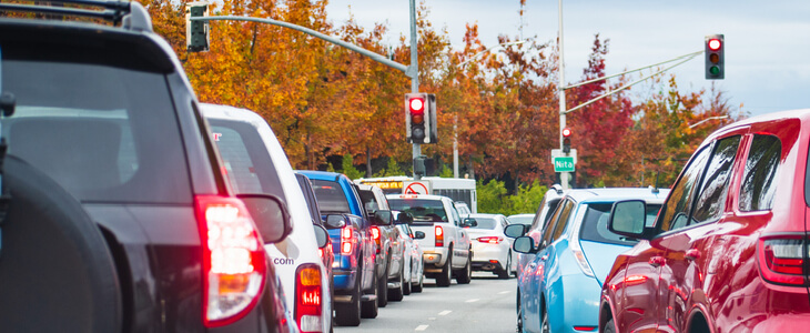 dozens of cars waiting at a red traffic light