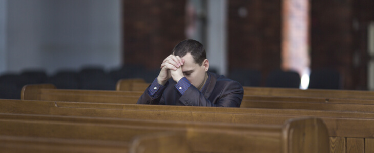 A Christian businessman praying at church