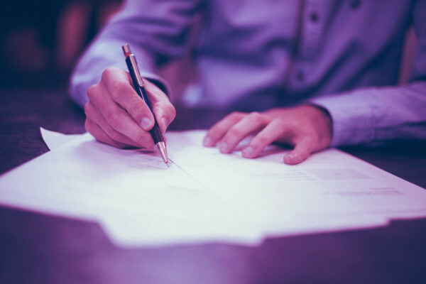 Man sitting at a desk signing papers