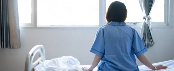Woman in hospital turned towards window.