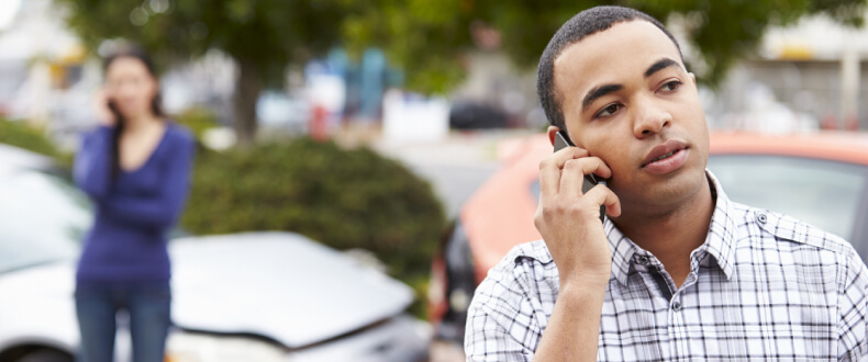 Man calling on his cellphone after a car accident