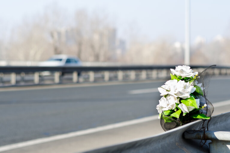 Artificial white roses flowers on the site of a traffic accident