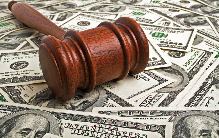 Wooden gavel laying on American dollars