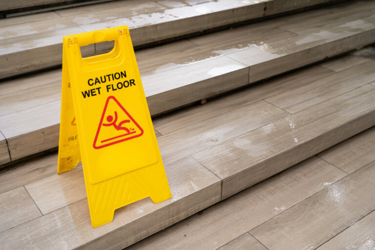 Yellow Caution slippery wet floor sign on the wet ground