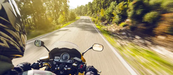 Motorcycle speeding down on an empty country road