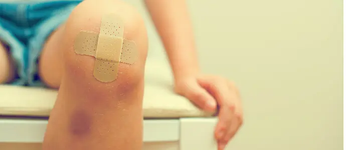 closeup of boy knee with bandaids, child injuries