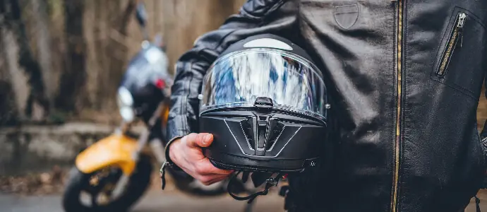 Motorcyclist holding helmet equipment