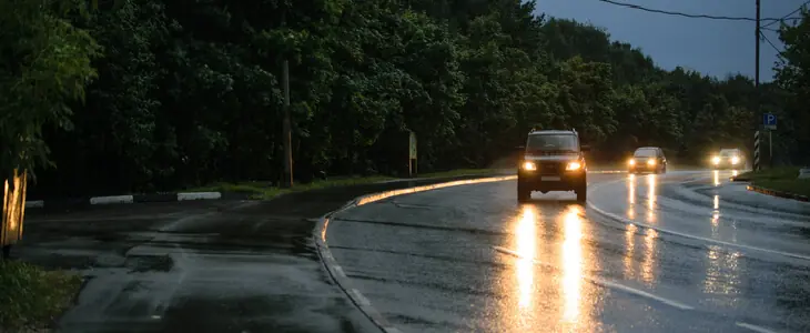 Cars driving at night on a wet road