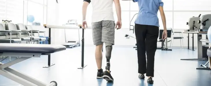 Amputee learning to walk with prosthetic leg.