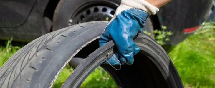 Defective car tire with rip.