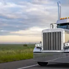 Truck driving on highway at sunset