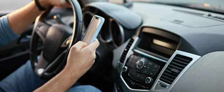 Hands of unrecognizable man driver using mobile phone while driving