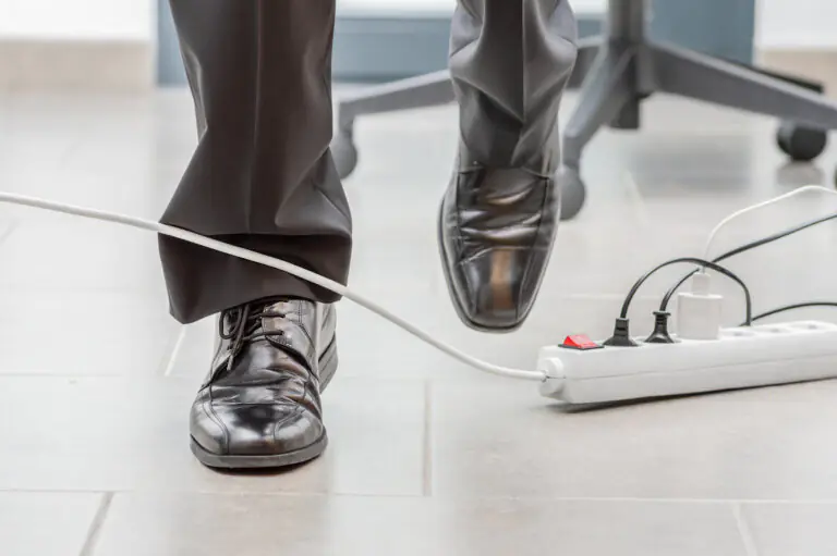 Close up of a businessman legs stumbling with an electrical cord